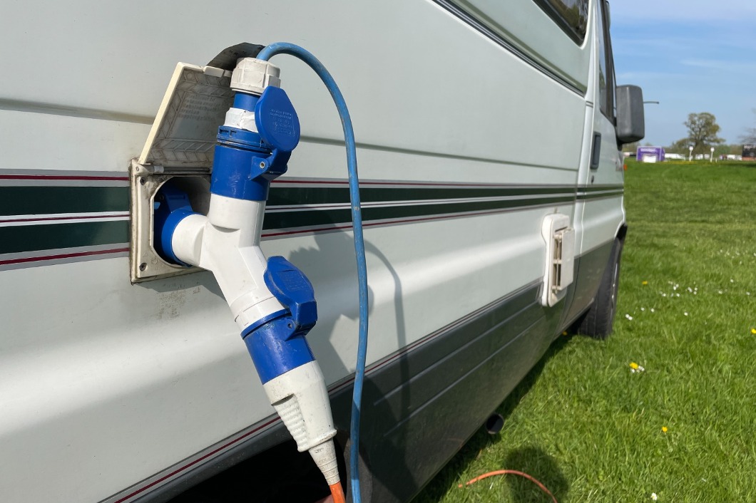 A blue cable connected to camper van