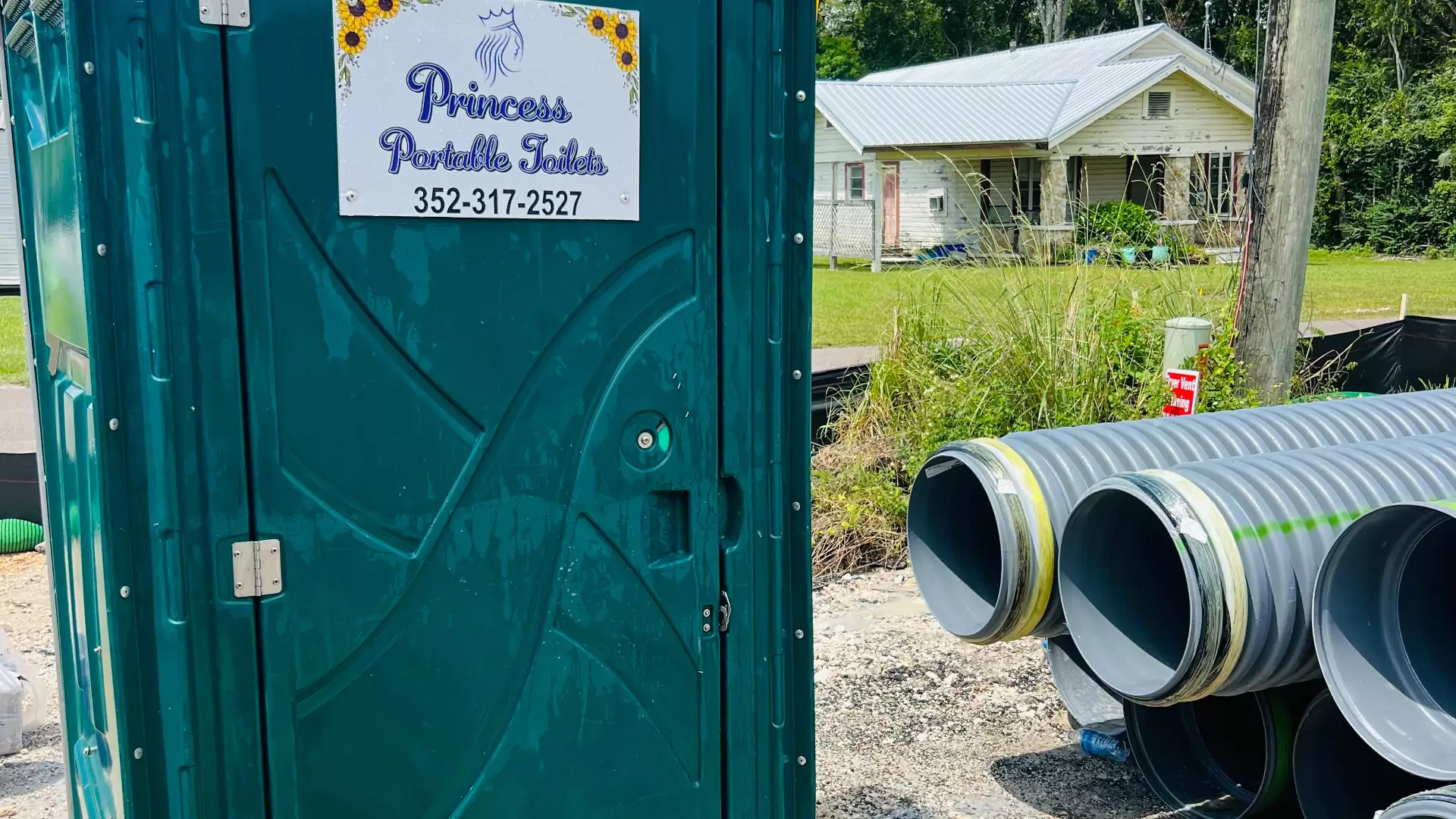 Princess Portable Toilets with a house visible in the background